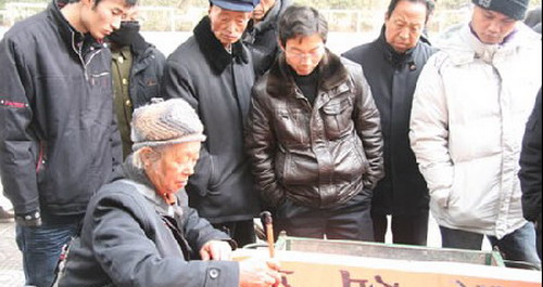 街頭潑墨書法變錢 貼春聯(lián)討吉慶汽車也來湊熱鬧