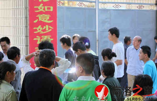 家們送考生進(jìn)入考場(chǎng)時(shí)，一縷光環(huán)閃現(xiàn)鏡頭中，這也許就是人們的理想與期待.jpg