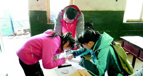 志愿者為困學(xué)生發(fā)放愛(ài)心助學(xué)金和御寒衣物