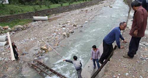 洪水沖毀簡(jiǎn)易便橋 村民自制滑索渡河