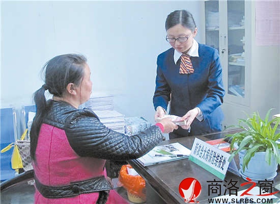 4月23日，謝自芳從工作人員手中接過大病保險報銷資金。