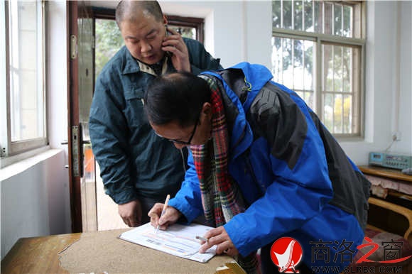 客戶收到包裹，直到確認無誤以后，商洛郵政公司快遞員朱軍鋒才會離開。