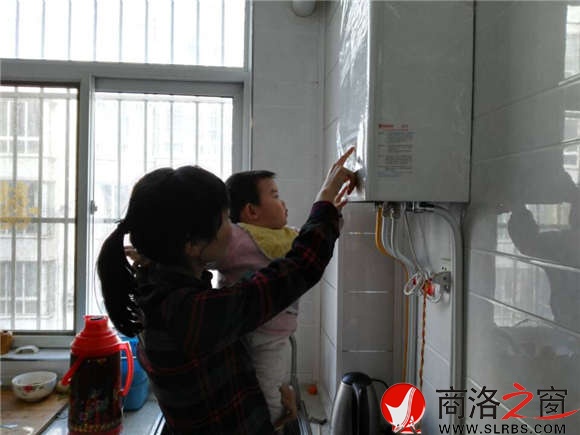 家住市區(qū)香菊小區(qū)的李女士正在操作自家剛剛安裝的燃?xì)獗趻鞝t，提升室內(nèi)的溫度。