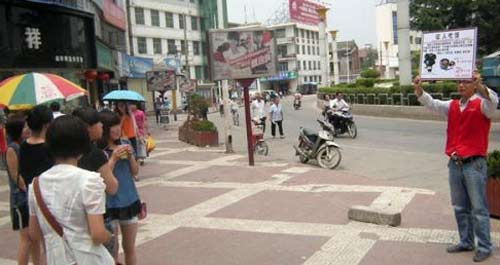 小伙街頭宣傳乙肝科普知識 高舉身份牌征人吃飯