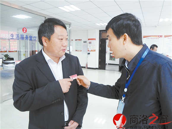 在鎮(zhèn)安縣新城社區(qū)便民服務(wù)大廳里，參會(huì)人員對(duì)社區(qū)工作人員掛牌上崗很感興趣。（記者 柯巖 攝）