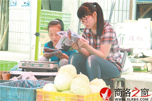 商州區(qū)楊斜鎮(zhèn)集市上，南思佳和妹妹在幫父母賣菜，閑暇之余，她們會(huì)拿起課外讀物翻一翻。在這個(gè)假期里，她們呆的最多的地方就是這個(gè)菜攤。